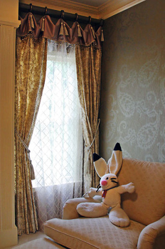 Feminine window treatment dressed with details and understated paisley wallpaper.