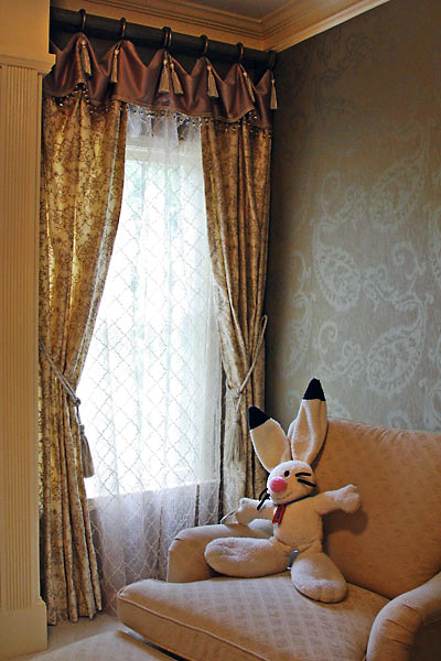 Feminine window treatment dressed with details and understated paisley wallpaper.