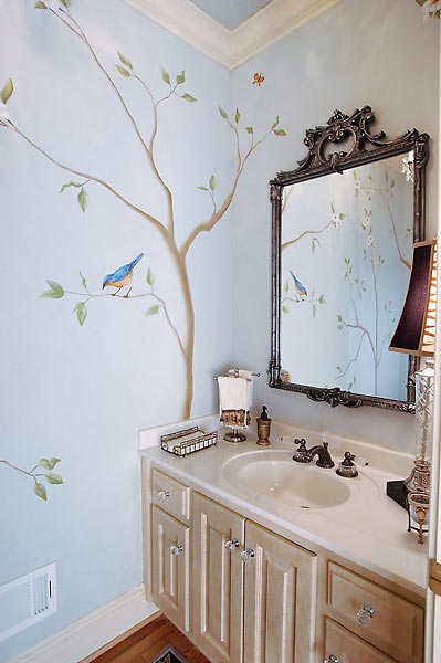 An oriole and butterfly painted on the walls of a powder room