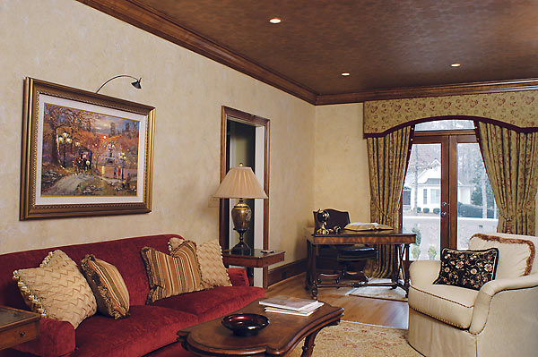 Artwork lighting, faux “copper tin” ceiling, faux painted walls, red sofa with custom pillows complete this home office.