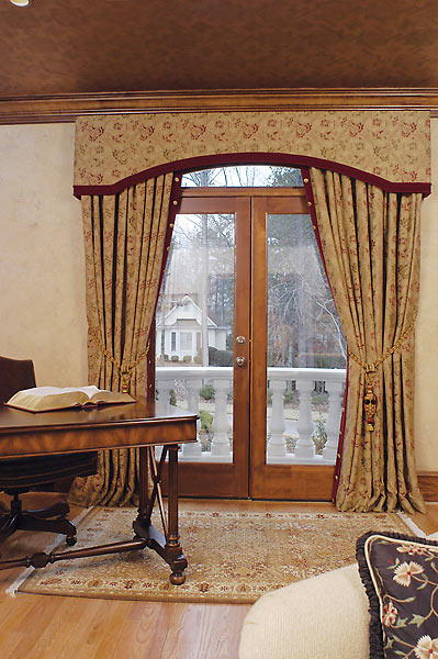 Custom window treatments for French doors including an arched valance over the transom window