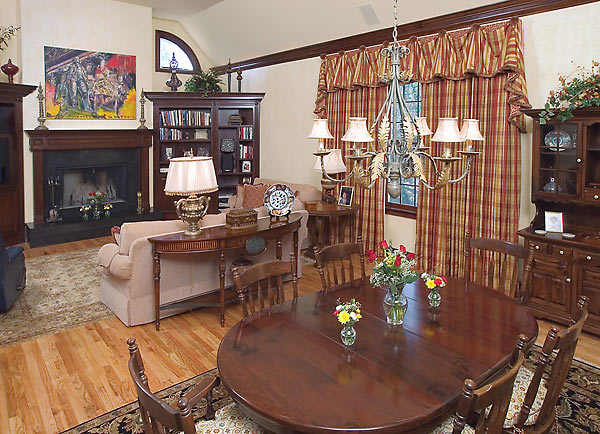 Modern artwork over the fireplace and custom window treatments in a great room