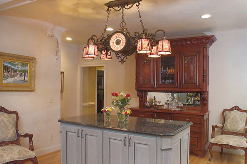 Unique chandelier over faux-painted island and custom-built bar in the kitchen